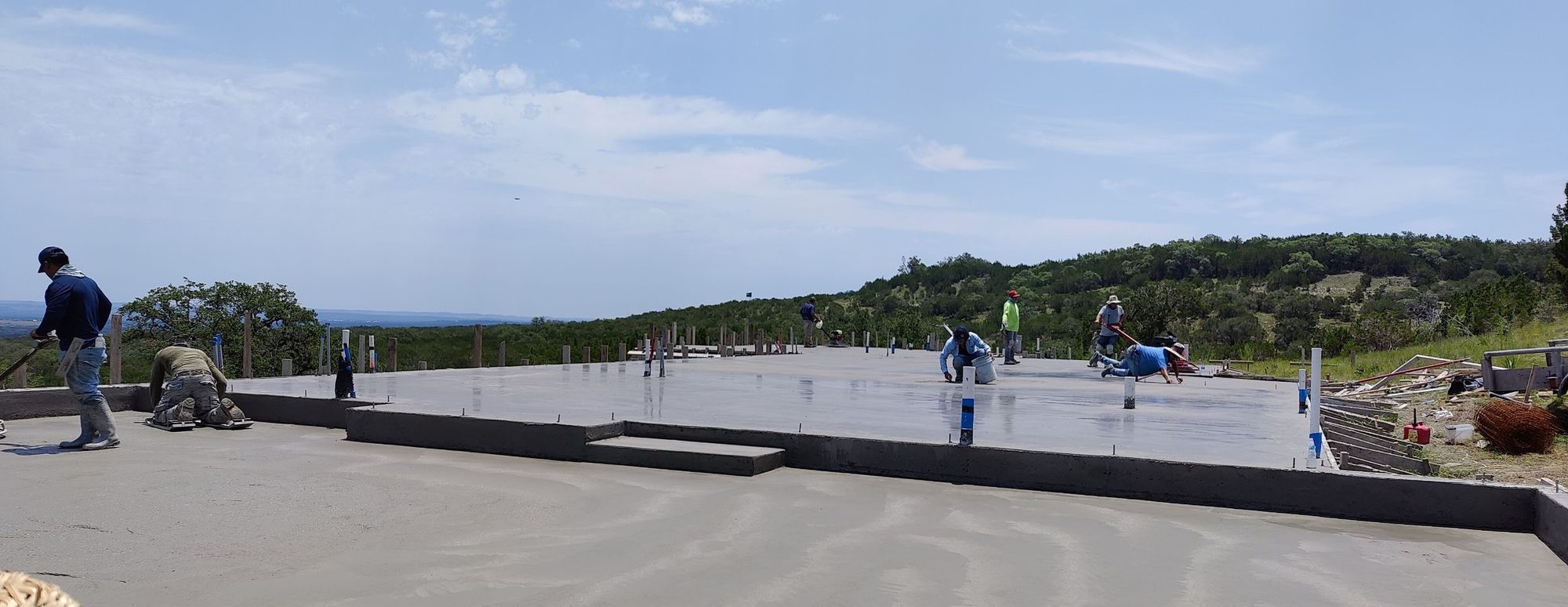 Texas Platinum Concrete crew finishing a large slab at sunset