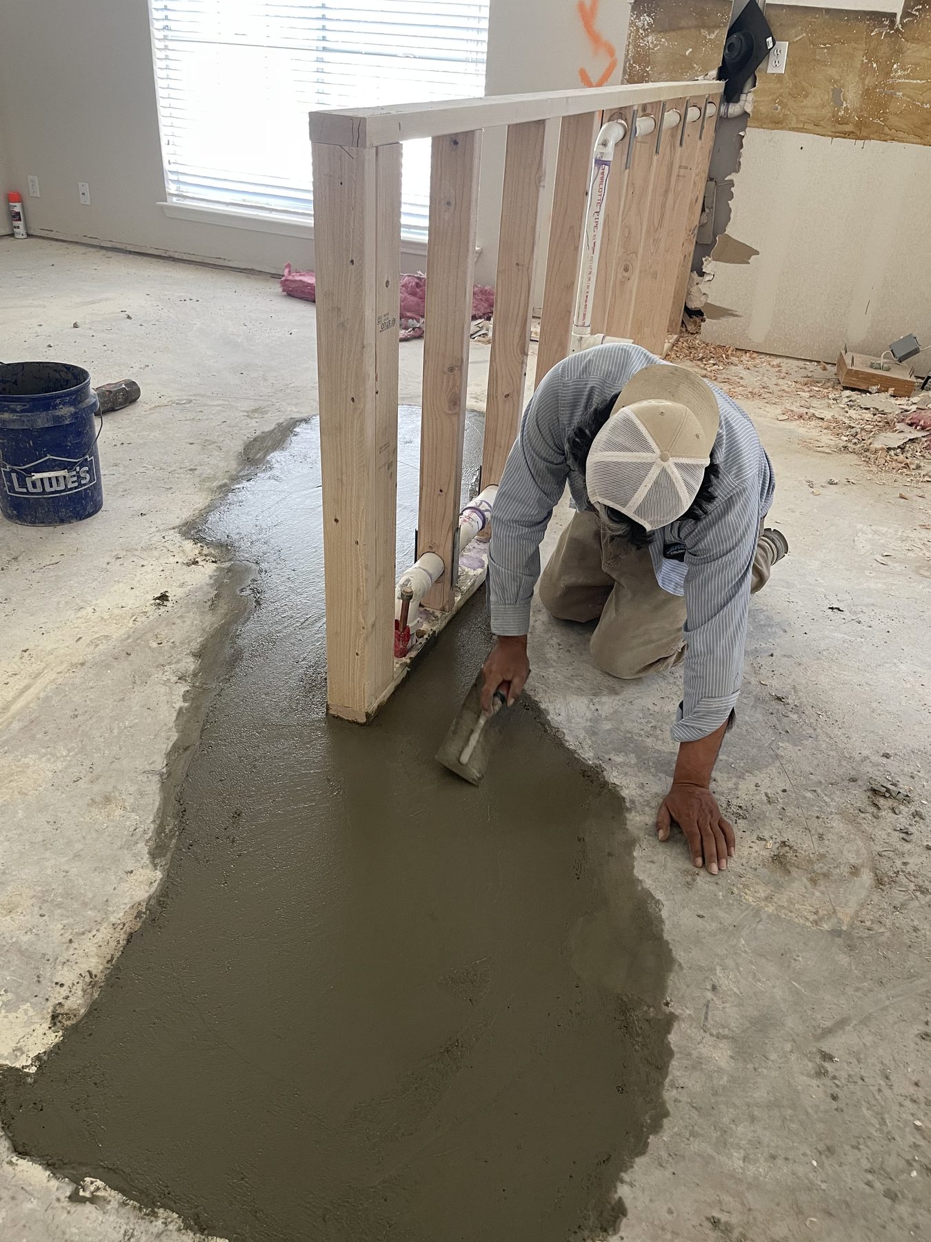 Crew member finishing a wet concrete slab