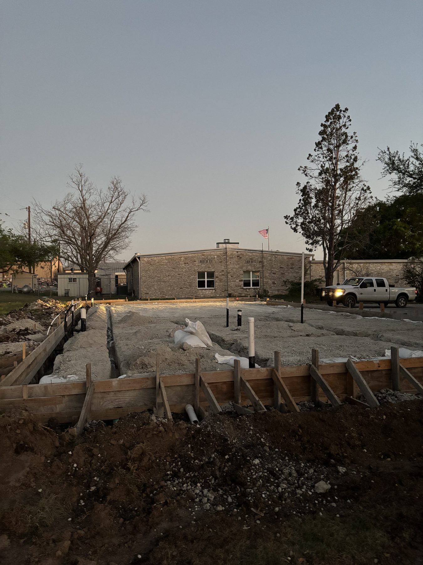 Forms set at dusk in front of the building