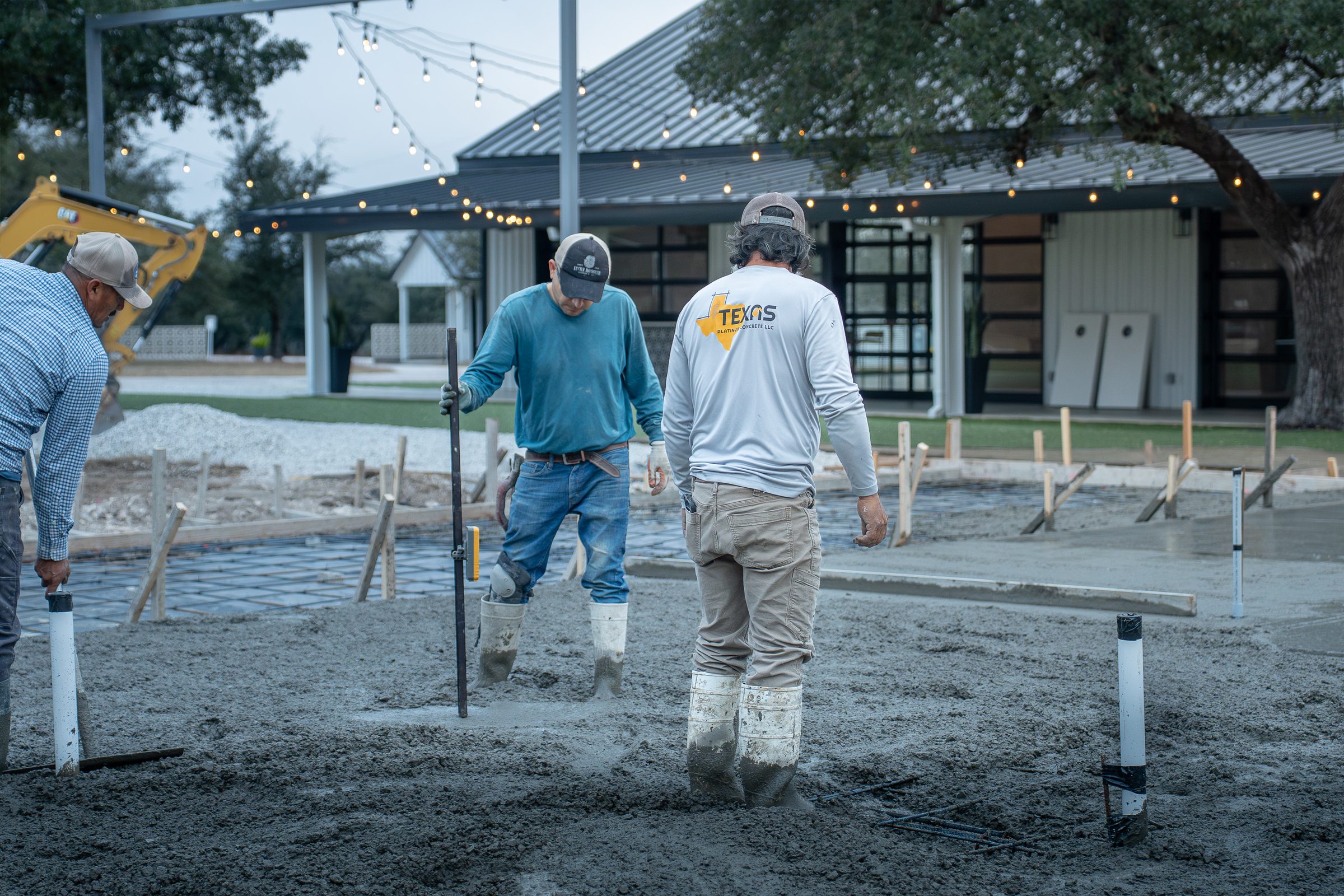Crew working the wet slab beside the pavilion