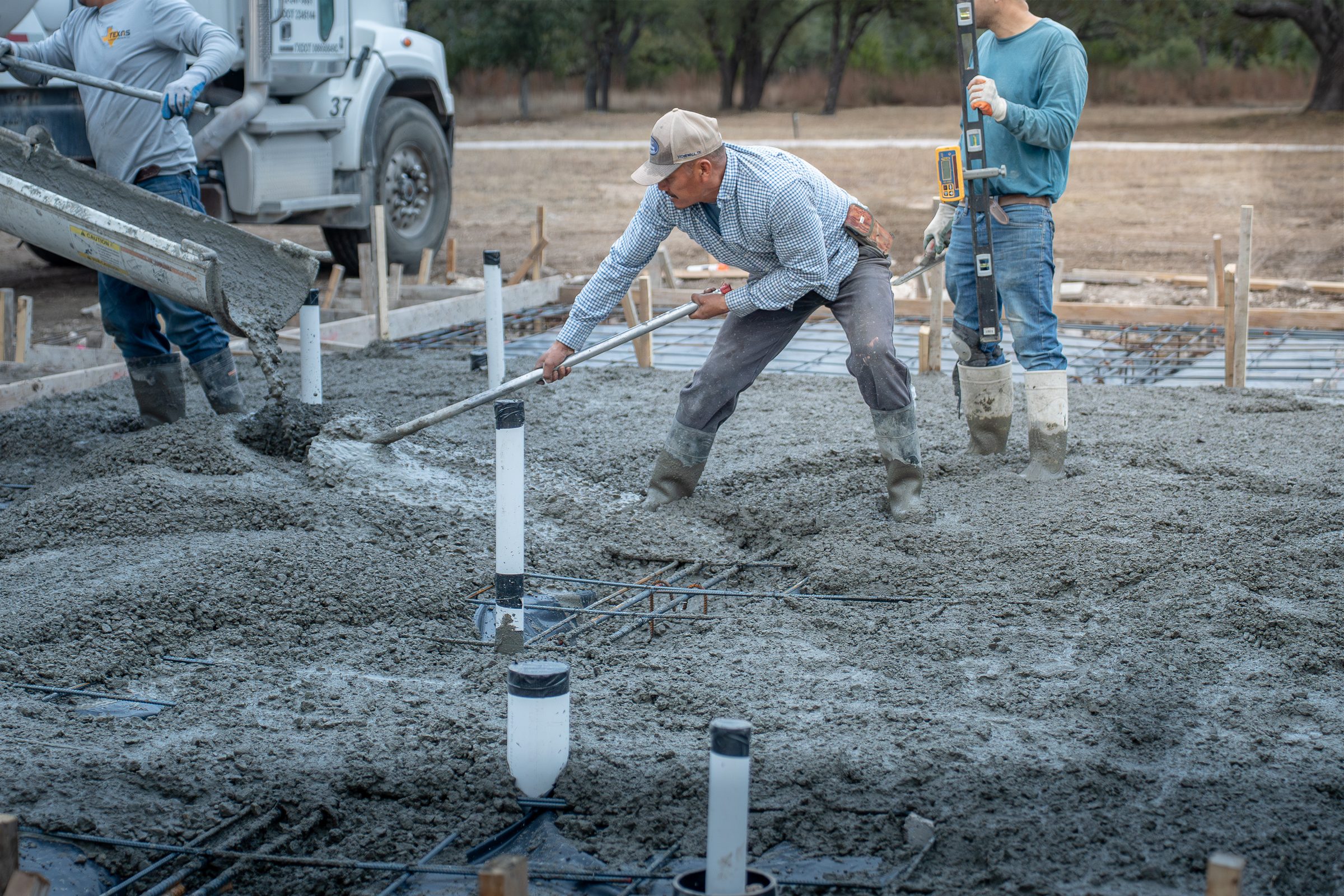 Raking fresh concrete off the chute into the forms