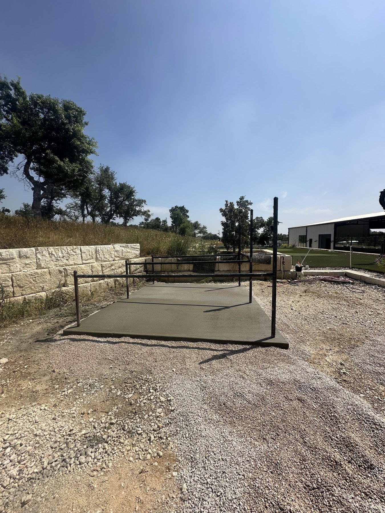 Small pad poured beside a stone wall