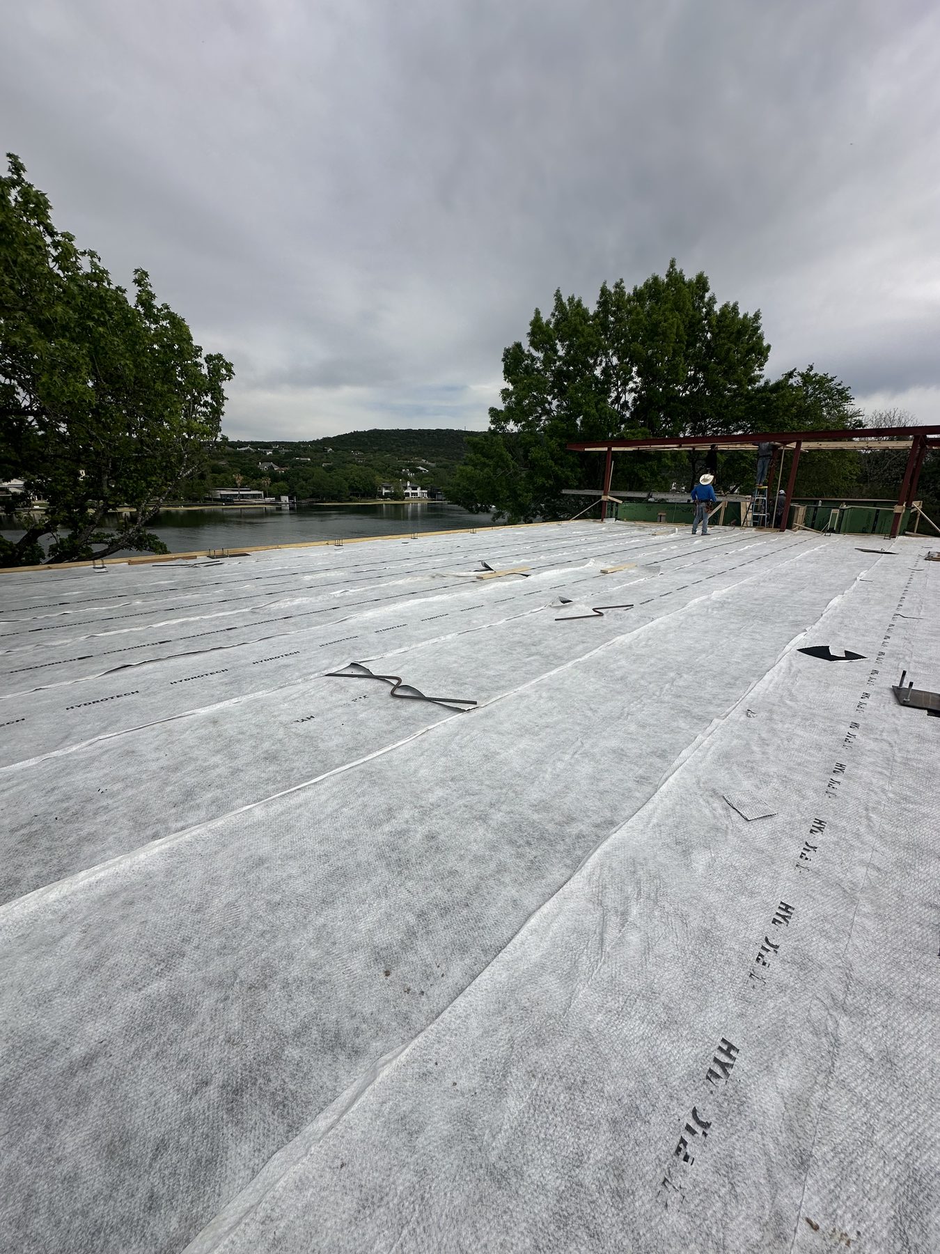 New slab foundation beside a house on a cloudy day